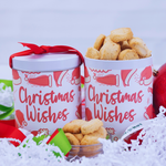 Two 'Christmas Wishes' tins filled with cookies on a snowy background